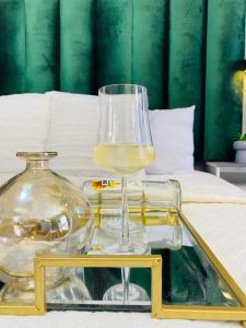un bicchiere di vino su un vassoio su un letto di Executive Galaxy Guest House Nkowankowa a Nkowakowa