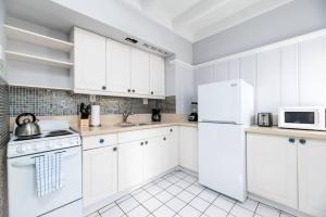 a white kitchen with white appliances and white cabinets at Ocean Breeze Free Parking Apt 3 in Fort Lauderdale
