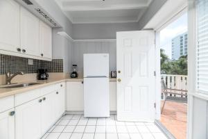 a kitchen with white cabinets and a white refrigerator at Ocean Breeze Free Parking Apt 3 in Fort Lauderdale