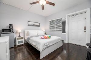 a white bedroom with a bed and a ceiling fan at Ocean Breeze Paradise Apt 5A in Fort Lauderdale