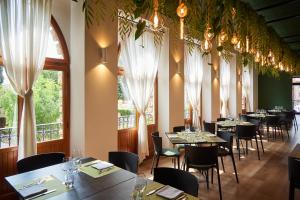 una sala da pranzo con tavoli, sedie e finestre di Hotel Ristorante La Ginestra a Recanati