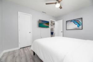 a white bedroom with a bed and a ceiling fan at Short Walk to Wilton Drive Apt1 in Fort Lauderdale