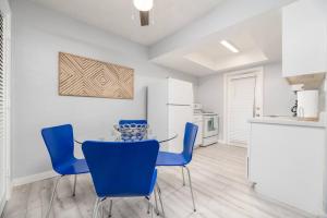 a dining room with a glass table and blue chairs at Short Walk to Wilton Drive Apt1 in Fort Lauderdale