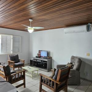 una sala de estar con sofás y techo de madera. en Casa 50m do mar, en Matinhos