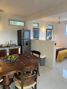 eine Küche und ein Esszimmer mit einem Tisch und einem Kühlschrank in der Unterkunft Amarilla (Amar y ya) in Cuatunalco