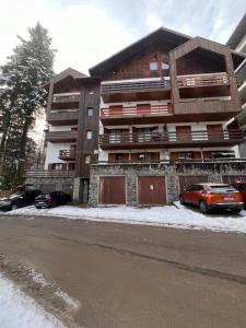 un edificio de apartamentos con coches estacionados frente a él en Vista Verde Apartment, en Sinaia