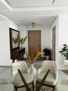 a living room with a glass table and two chairs at Harhoura Modern Flat in Temara