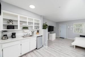 Il comprend une cuisine blanche avec un évier et un salon. dans l'établissement Just Off Wilton Drive Apt 2, à Fort Lauderdale
