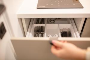 a person reaching into a drawer with utensils at Lukiskes square apartments (Oldtown) in Vilnius