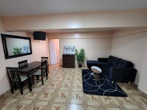 Hotel La Pampa في Alto Hospicio: غرفة معيشة مع أريكة سوداء وطاولة