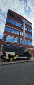 a black van parked in front of a building at Hotel La Pampa in Alto Hospicio