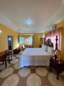 a bedroom with a large bed and a living room at Veronica Homestay Lucea Jamaica in Lucea