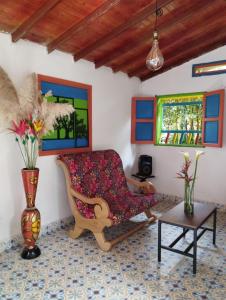 una sala de estar con una silla y un jarrón con flores en Galilea en Santa Elena