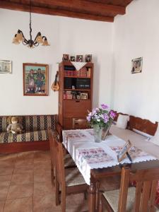 a dining room with a table and a couch at οικία ΦΥΝΤΙΚΑΚΗ - SKALA in Anópolis