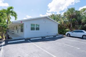 una casa blanca con un coche aparcado en un estacionamiento en Just Off Wilton Drive Apt 8, en Fort Lauderdale