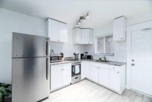 a kitchen with white cabinets and a stainless steel refrigerator at Comfy Condos at Middle River Apt 2 in Fort Lauderdale
