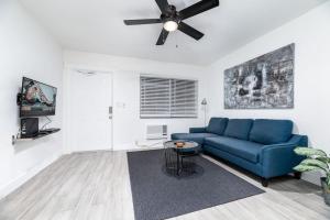 a living room with a blue couch and a ceiling fan at Comfy Condos at Middle River Apt 2 in Fort Lauderdale