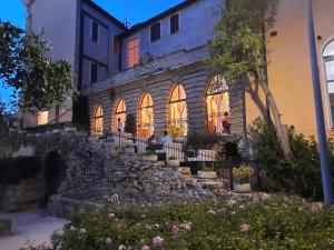 un antiguo edificio de piedra con gente sentada en la ventana en Hotel Ristorante La Ginestra, en Recanati