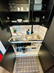 una pequeña cocina con fregadero y encimera en New Tiny Home Uptown Phoenix (Unit E), en Phoenix