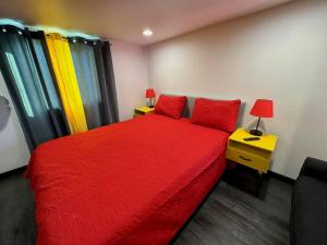 1 dormitorio con cama roja y mesita de noche amarilla en New Tiny Home Uptown Phoenix (Unit E), en Phoenix