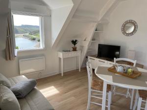 索宗Appartement T2 vue mer Sauzon terrasse et parking privés的带桌子和电视的客厅