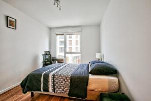a bedroom with a bed and a window at Grand apart Bagneux in Bagneux