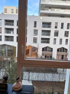 Una ventana con vista a un gran edificio. en Chambre privée dans un appartement en colocation, parking gratuit, en Bagneux