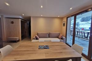 un salon avec une table et un canapé dans l'établissement L'écrin des neiges - Sauna, à La Féclaz