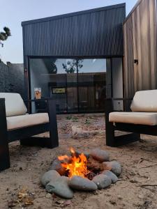 a fire pit in a yard with two chairs at Algarrobo Casa Canelo in Algarrobo