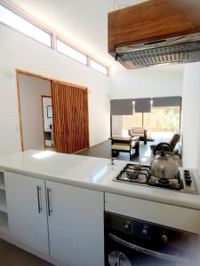 a kitchen with a stove top oven next to a living room at Algarrobo Casa Canelo in Algarrobo