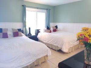 a bedroom with two beds and a vase of flowers at Affordable Two Bedroom Tropical Condo - Private Beach, Pools, Hot Tub in St. Petersburg