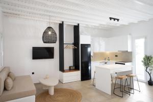 a kitchen and living room with white walls at Loom Suite Ornos in Mikonos