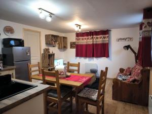 a kitchen with a table and chairs in a room at La sapinette avec jaccuzzi in La Bâthie