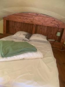 a large white bed with a wooden headboard and pillows at Location Nuit Studio Port Gruissan in Gruissan