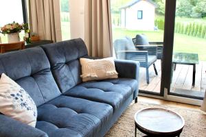 a blue couch in a living room with a patio at Galena i Gnejs in Stronie Śląskie