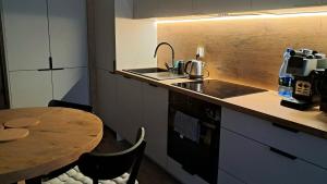 a kitchen with a table and a sink and a counter at Apartament Drwęcka in Ostróda