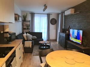a living room with a couch and a table with a tv at Apartament Drwęcka in Ostróda