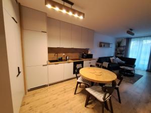 a kitchen and living room with a table and a kitchen at Apartament Drwęcka in Ostróda