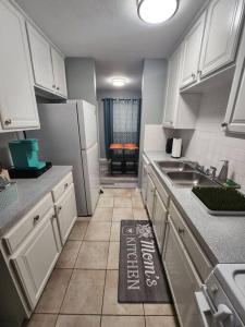a kitchen with white cabinets and a kitchen rug on the floor at Blue Shark *B2* @ Bellaire 1BR King Apartment Near Medical Center in Houston
