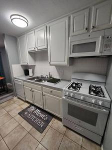 a kitchen with white cabinets and a stove and a sink at Blue Shark *B2* @ Bellaire 1BR King Apartment Near Medical Center in Houston