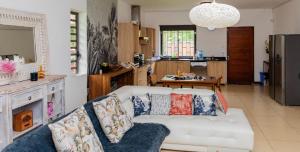 ein Wohnzimmer mit einem weißen Sofa und einer Küche in der Unterkunft Grand Bay Luxury Villa with Pool & Garden in Grand Baie