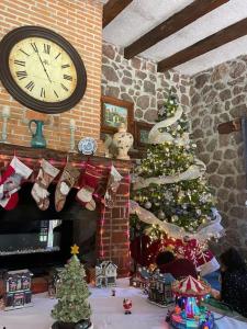 庫埃納瓦卡的住宿－¡Nueva! Bamboo Tesoro del Bosque，一间客厅,配有圣诞树和钟