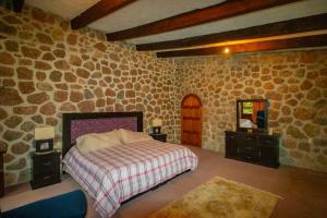 庫埃納瓦卡的住宿－¡Nueva! Bamboo Tesoro del Bosque，一间卧室设有一张床和石墙