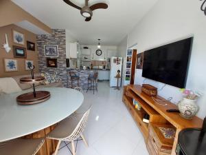 sala de estar con mesa y TV grande en apartamento vizinho ao mar, en Porto Seguro
