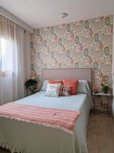 1 dormitorio con 1 cama con pared de papel pintado en Apartahotel La Chipranera, en Castejón de Monegros