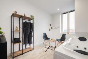 uma casa de banho branca com uma banheira branca e um lavatório. em Suite de JIJI - Suite Chic Spa - Home-Cinéma & Netflix - Wi-fi em Saint-Étienne