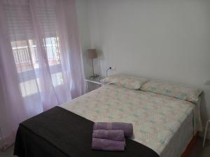 Un dormitorio con una cama con una toalla morada. en Apartamento de 3 dormitorios Jardinillos Centro, en Jaén