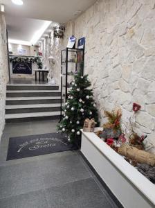 a christmas tree in a lobby with a stone wall at B&B La Grotta in Nicolosi
