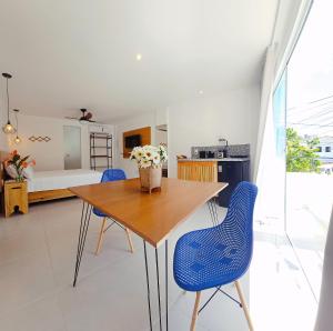 ein Esszimmer mit einem Holztisch und blauen Stühlen in der Unterkunft Estúdio Arruda in Itacaré