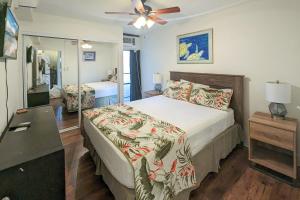 um quarto com uma cama e uma ventoinha de tecto em Kihei Holiday 215 - a Charming 2BR, 1BA Condo, AC em Kihei